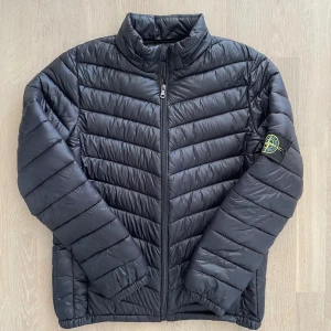 Stone Island dunjacka - Säljer nu min bekväma Stone Island dunjacka. | Skön passform och varm. | Storlek S. | Fint skick, obs mini hål på sista bilden, går lätt att laga. | Osäker på äktheten därav priset men finns certilogo. | Släng iväg en signal vid funderingar så svarar jag snabbt. |
