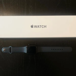 Apple Watch SE 44mm Midnight - Apple Watch SE (2nd gen) med 44mm boett i midnight aluminium och matchande sportarmband. Stilren, svart digital display och rundade former. Perfekt för dig som vill ha koll på notiser, hälsa och träning direkt på handleden.