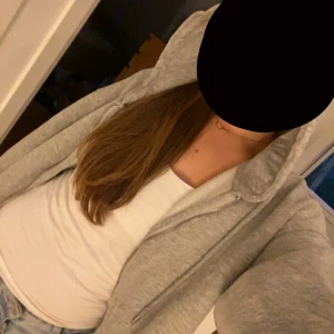 Grå hoodie med dragkedja från Gina Tricot - Mysig grå hoodie från Gina Tricot i storlek XXS men är oversize så skulle säga att den passat s och xs bättre. Tröjan har huva med snörning, dragkedja framtill och ribbade muddar vid ärmslut och nederkant. Perfekt för chill dagar och enkel att matcha med jeans eller leggings.  Ny pris 400kr.