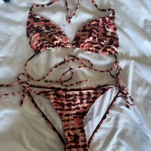 Mönstrad bikini från Gina Tricot - Snygg trekantsbikini från Gina Tricot med rosa, brunt och beige camouflage-mönster. Aldrig använd
