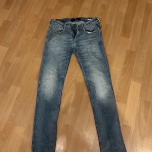 Replay Anbass ljusblå jeans, W28 - Snygga ljusblå Replay Anbass jeans med klassisk femficksdesign och dragkedjegylf. Jeansen har en slim passform och är tillverkade i stretchig denim för extra komfort. Perfekta för dig som gillar en modern och stilren look.