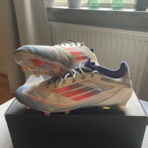 Adidas F50 fotbollsskor blå/röd - Säljer ett par Adidas F50 FG/AG. Skorna är i bra skick och har inga hål eller liknande. 