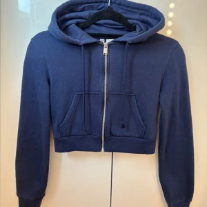 Marinblå croppad hoodie med dragkedja - Marinblå croppad ziphoodie ifrån HM. Säljer för att jag inte använder den längre. Den är i storlek XS men passar även S. Skriv för mer bilder!💓 