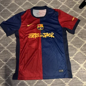 FC Barcelona Lamine Yamal/Travis scott matchtröja Nike/ÄKTA!! - Säljer en FC Barcelona matchtröja från Nike med Lamine Yamal och nummer 19 på ryggen. Tröjan är i klassiska rödblå färger, har korta ärmar och är tillverkad i Dri-FIT material. Tryck i gult framtill och baktill samt klubbmärke på bröstet.