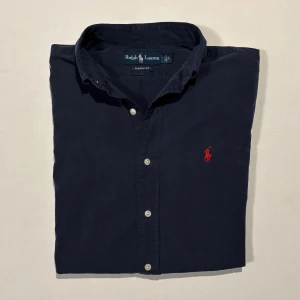 Marinblå Ralph Lauren Skjorta - Riktigt fin marinblå Ralph Lauren skjorta✨. Grymt bra skick! Storlek (S). Passar perfekt till höst/vintern. Nypris ligger runt 2200kr, säljs för 700kr! Pris kan diskuteras vid snabb affär. MVH