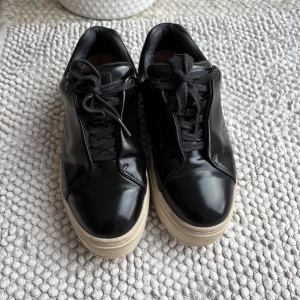 Eytys skor - Snygga svarta sneakers från Eytys i blankt skinn. Använda men i fint skick. 