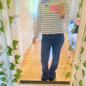 Blå bootcut jeans från Gina Tricot - Snygga blå jeans från Gina Tricot i storlek 170. Modellen har bootcut-ben, framfickor med markerade sömmar och klassiska bakfickor. Jeansen är i stretchigt denimtyg och har en normal passform med medelhög midja.