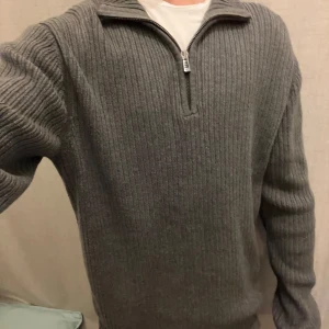 Grå ribbad half zip-tröja Calvin Klein - Snygg grå ribbstickad tröja från Calvin Klein med half zip-dragkedja och hög krage. Långärmad modell i mjukt material som sitter skönt och passar perfekt till lager-på-lager. Enkel men stilren design som funkar till det mesta. Skickar inom 1-2 dagar👏. Svarar ofta snabbt så hör av er vid frågor och funderingar🙌. kom gärna med prisförslag så kan vi säkert lösa något som funkar för båda😄
