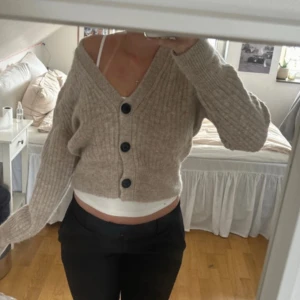 Stickad cardigan🤍 - Säljer en beige, ribbstickad kofta med tre stora svarta knappar framtill. Modellen är v-ringad hals och långa ärmar. Perfekt för dig som gillar en chill och trendig look. Supermjuk och skön att ha på sig.nypris 1050kr 