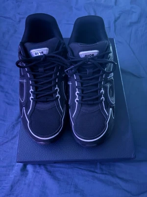 Svarta Dior B30 - Säljer ett par svarta Dior B30 skor. Skorna har en chunky sula och tydlig Dior-logga på sidan och plösen. Snygg sportig design som sticker ut och passar perfekt till streetwear eller casual outfits.
