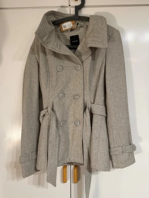 Grå kappa - Fin grå kappa ifrån Vero Moda / sellpy Har endast prövat & finns en fläck vid kragen. Strl XL, liten i strl mera en vanlig L