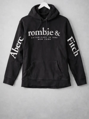 SÄLLSYNT Svart hoodie Abercrombie & Fitch - Svart hoodie från Abercrombie & Fitch med stor vit logga på bröstet och text längs båda ärmarna. Klassisk känguruficka framtill och justerbar huva med snören. Tillverkad i mjukt material som känns skönt mot huden. EXTREMT EFTERTRAKTAD