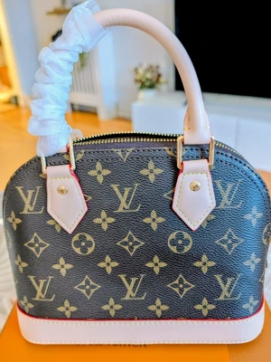 Iouis Vuitton Väska  - Mer än bara en väska , det är en statement-piece. Ta din utstrålning till nästa nivå och låt alla blickar vändas mot dig.