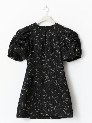 Svart klänning med puffärmar - Supersnygg svart klänning med blommigt mönster och markerade puffärmar och silver detaljer . Har bara använt en gång 