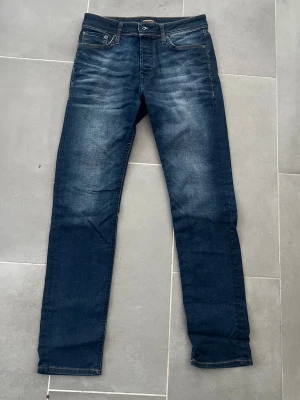 Mörkblå Slim fit jeans - Säljer ett par mörkblå slim fit jeans med snygga slitningar. Storlek 30/32 och är i ett fint skick utan några defekter. Skriv vid frågor!😀