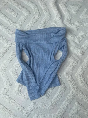 Ljusblå offshoulder topp Stradivarius - Säljer en ljusblå ribbad offshoulder topp från Stradivarius i storlek S. Toppen är croppad med lång ärm och har en snygg, åtsittande passform. Ej andvänt