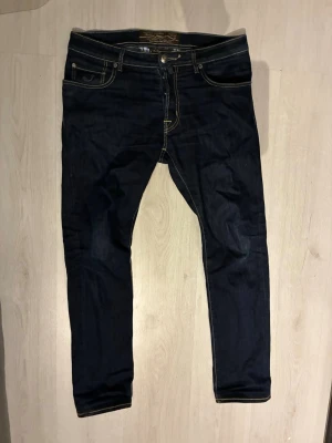 Jacob cohen Jeans - Snygga mörkblå slim fit jeans från Jacob cohen. Den är sparsamt använda och patchen och tyget är i bra skick. Modellen heter 688 och storleken är 33. Perfekta för en trendig och stilren look. Vid fler frågor får ni gärna skriva👍