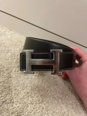 H Bälte Svart - Stilrent svart H-bälte. Storlek 110cm, helt nytt. Hör av vid funderingar