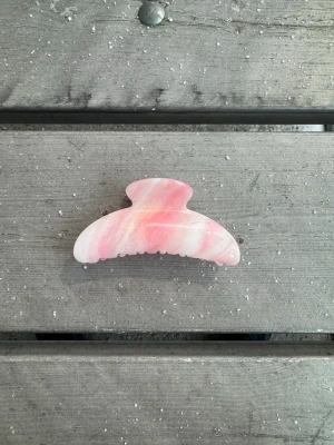 Rosa hårklämma i marmormönster - En snygg hårklämma i rosa och vitt marmormönster. Klämman har en klassisk bågform och innehåller silikon på insidan som skapar en bättre greppyta. Perfekt för att snabbt sätta upp håret med stil och få det att sitta på plats hela dagen.💕