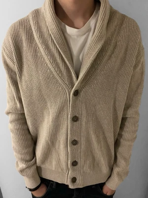 John Henric cardigan - Snygg beige stickad kofta från John Henric med sjalkrage och knappar framtill. Koftan har ribbstickad struktur och är tillverkad i ett mjukt material som passar perfekt till lager-på-lager. Enkel att matcha med t-shirt eller skjorta.