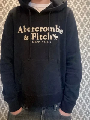 Abercrombie & Fitch hoodie  - Tja, säljer denna Abercrombie & Fitch hoodien i mycket bra skick. Storleken är M men sitter mer som XS och passar perfekt för dig som är 165-170 cm lång! Modellen på bilden är 170. Mitt pris är 699, men kan givetvis diskuteras vid snabb affär! Mått Längd: 57 cm Bred: 50 cm. Hör av er vid frågor🙌