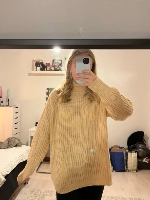 Beige oversized stickad tröja - Beige (varm nyans) stickad tröja med hög hals och avslappnad passform. Tröjan har ett grovt stickat mönster och långa ärmar. Storlek M - från lager 157🧡