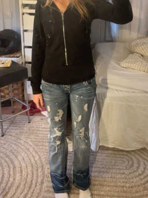 Blå slitna bootcut jeans - Säljer ett par blå bootcut jeans med slitningar, det stretchiga och insydda mellan benen, midje mått 38cm tvärs över midjan och 78cm innebenslängd. Skriv vid frågor💘