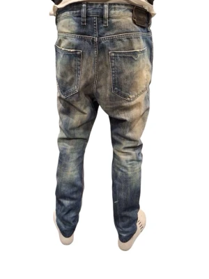 Diesel jeans - Säljer ett par blå jeans med coola slitningar och tvättade detaljer. Jeansen har raka ben och är uppsydda från 32 till 30. De har en snygg vintage-look som passar till allt. W28.