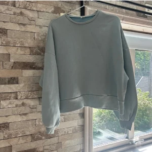 Ljusblå sweatshirt från NLY Trend - En ljusblå sweatshirt från NLY Trend med avslappnad passform och ribbade muddar vid ärmslut och nederkant. Tröjan har rund halsringning och långa ärmar, perfekt för en chill och stilren look.