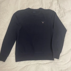 Mörkblå sweatshirt från GANT - Säljer en mörkblå sweatshirt från GANT med rund hals och diskret logga broderad på bröstet. Inga skador eller liknande.