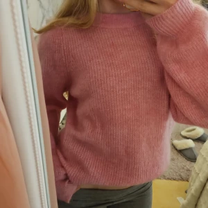 Rosa stickad tröja från Selected Femme - Supermysig rosa stickad tröja från Selected Femme i storlek XS. Tröjan har en rund halsringning, ballongärmar och ribbade muddar. Passar lika bra till jeans som till kjol. Mycket bra skick, aldrig använd – visst noppigt och luddigt, men i övrigt hel och fin. Känns något sträv mot huden så rekommenderas med ett linne/t-shirt under för bästa komfort. Nypris runt 700 kr. Säljer den då jag inte får någon användning för den. Samma sonns som min tidigare!