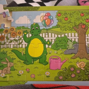 Bolibompa träpussel - Färgglad Bolibompa  pussel med en glad grön dinosaurier, ballonger och djur som kanin, groda och snigel i en trädgård. Perfekt för  barn som gillar pussel och den populära Bolibompa. Pussel är lekfull och pedagogisk med fina illustrationer. Knappt använd. 