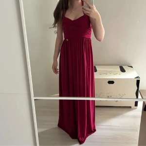 Röd balklänning  - Supersnygg vinröd långklänning med breda axelband och korsad rygg. Perfekt finare tillfällen eller bal.