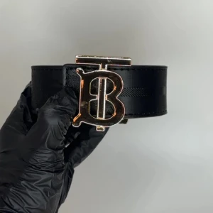 Burberry vändbart skärp med monogram - Säljer mitt fina Burberry-bälte i klassiskt rutigt mönster. Äkta designerbälte i mycket bra skick – endast använt ett fåtal gånger. Passar både dam och herr unisex och ger vilken outfit som helst en lyxig touch.