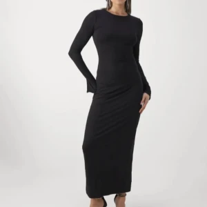 Svart långärmad långklänning - Elegant svart långklänning med långärmad design (slits på varje arm vid handleden)  Klänningen har en tight passform som framhäver figuren och är perfekt för en stilren look. Säljer den då den bara legat i garderoben och använts vid två tillfällen. 