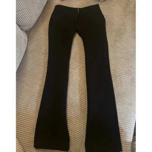 Svarta bootcut och low waist kostymbyxor  - Superfina kostymbyxor från BikBok! Ganska smala vid låren, så de sitter bäst på dig med lite smalare ben. Väldigt snygg passform och skönt material!