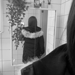 Svart parkas från Canada Goose med päls - Säljer en svart parkas från Canada Goose med stor huva och fluffig ljus päls runt kanten. Jackan har klassisk logga på ärmen, dragkedja och knappar framtill. Perfekt för kalla dagar och riktigt snygg streetstil.