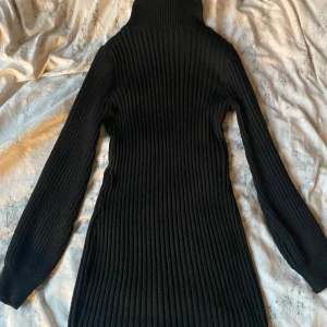 Svart ribbad stickad poloklänning - Säljer en svart stickad klänning med polokrage och långa ärmar. Klänningen är ribbad och har en tight passform som framhäver siluetten. Perfekt för kyligare dagar och enkel att styla med boots eller sneakers. En höst och snygg klänning som är oanvän.+frakt 50❤️ 