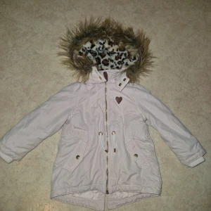 Parkajacka  - Söt ljusrosa parkajacka från H&M med fuskpäls på huvan och leopardmönstrat foder. Jackan har dragkedja, knappar, snörning i midjan och två fickor med lock. Perfekt för kyliga dagar och har quiltat innerfoder för extra värme.