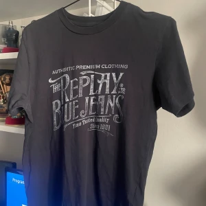 Svarta t-shirts från Replay - Två svarta t-shirts från Replay med tryck framtill. Den ena har stort vintageinspirerat tryck med 'Replay Blue Jeans', den andra har Replay-logga och liten etikett på ärmen. Klassisk passform och rund hals. Perfekta för en avslappnad streetstil.