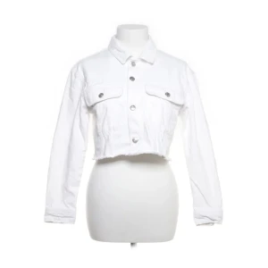 Vit jeansjacka  - Snygg vit croppad jeansjacka från NA-KD. Med silvriga knappar,klassisk krage och rå kant nertill. Perfekt för dig som vill ha en fräsch och trendig look.