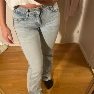 Ljusblå jeans från Pull&Bear, bootcut - Säljer ett par ljusblå jeans från Pull&Bear. Jeansen har hög midja, raka ben med lätt utsvängning och femficksdesign. Tillverkade i bomull med snygg tvättad look och detaljerade sömmar. Perfekta för en avslappnad och trendig stil. Rumpan ser perfekt ut i dessa byxor och dessa var mina absoluta favoriter men  passar ej längre, lite slitna ner till.