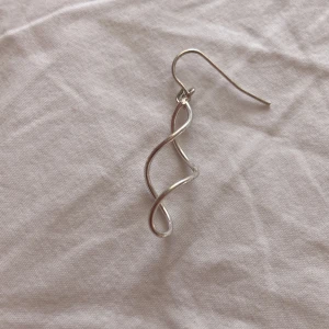 Silvrigt snirkligt örhänge - Unikt örhänge i silverfärgad metall med en snirklig, böjd design som ger en cool och modern känsla. Perfekt för dig som gillar minimalistiska men ändå iögonfallande accessoarer ✨🫶🏻✨