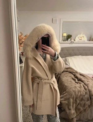 Beige kappa  - Köpt från SSSHOP Nypris är 3599kr Pälsen sitter fast med hjälp av knappar som går att knäppa av Storlek XS-S Liten fläck vid fickan visas på bild