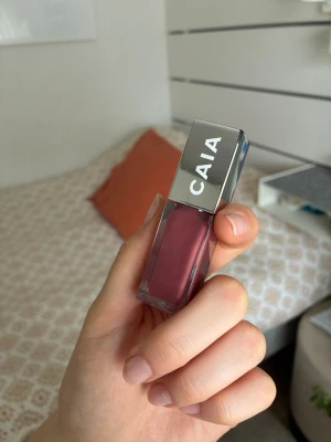 CAIA läppglans Bryce - Säljer ett CAIA läppglans i färgen Bryce. Glanset har en snygg mauve-rosa ton och kommer i en stilren fyrkantig förpackning med silvrigt lock. Applikatorn är mjuk och gör det enkelt att få ett jämnt resultat. Perfekt för dig som vill ha glansiga, fylliga läppar. Använd till hälften ungefär.