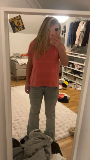 Korallrosa blus från H&M - Säljer en korallrosa blus från H&M med korta ärmar och rund halsringning. Toppen har ett fint spetsinspirerat mönster i horisontella rader och är lätt croppad. Perfekt för dig som gillar färg och vill ha en söt och enkel topp till sommaren.