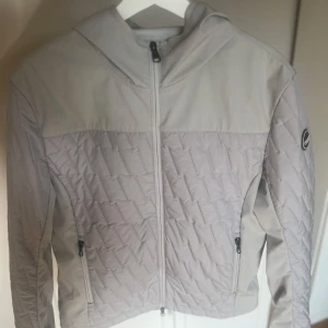 Ljusgrå quiltad jacka från Colmar - Snygg ljusgrå jacka från Colmar med quiltad design och huva. Nästintill oanvänd!