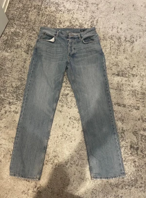 Blå raka jeans från Zara - Snygga ljusblå jeans från Zara med klassisk femficksdesign och raka ben. Jeansen har knappgylf och bälteshällor, tillverkade i slitstarkt bomullsjeansmaterial. Perfekt för dig som gillar en enkel och clean look.