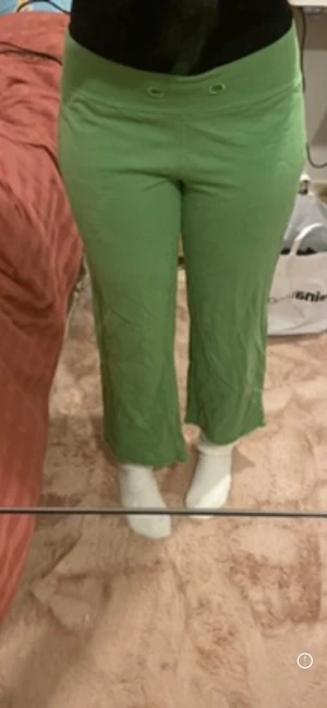 Gröna croppade mjukisbyxor - Säljer ett par gröna mjukisbyxor med croppad längd och normal passform. Det står ingen strl på byxorna. Jag är ca Xs skulle säga det passar det o över/ under då det är stretchigt material.