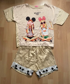 Beige pyjamas-set - Beige pyjamas-set. Shortsen har loose passform och resår i midjan för extra komfort. Perfekta för chill dagar hemma eller sleepovers med vänner.